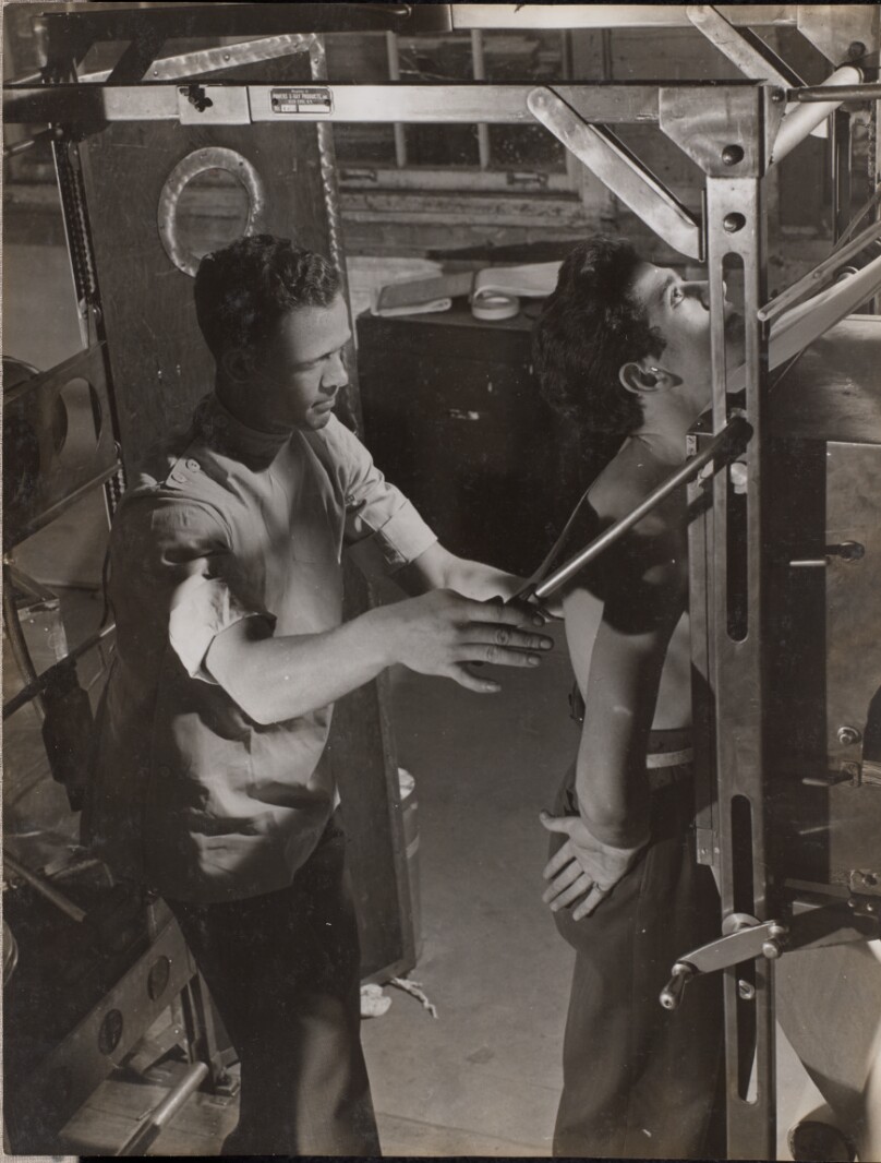 [Doctor uses a machine to assess a patient's spine]