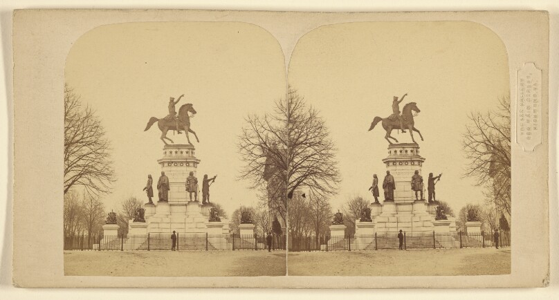 [View of town square with statue of man on horse at center]
