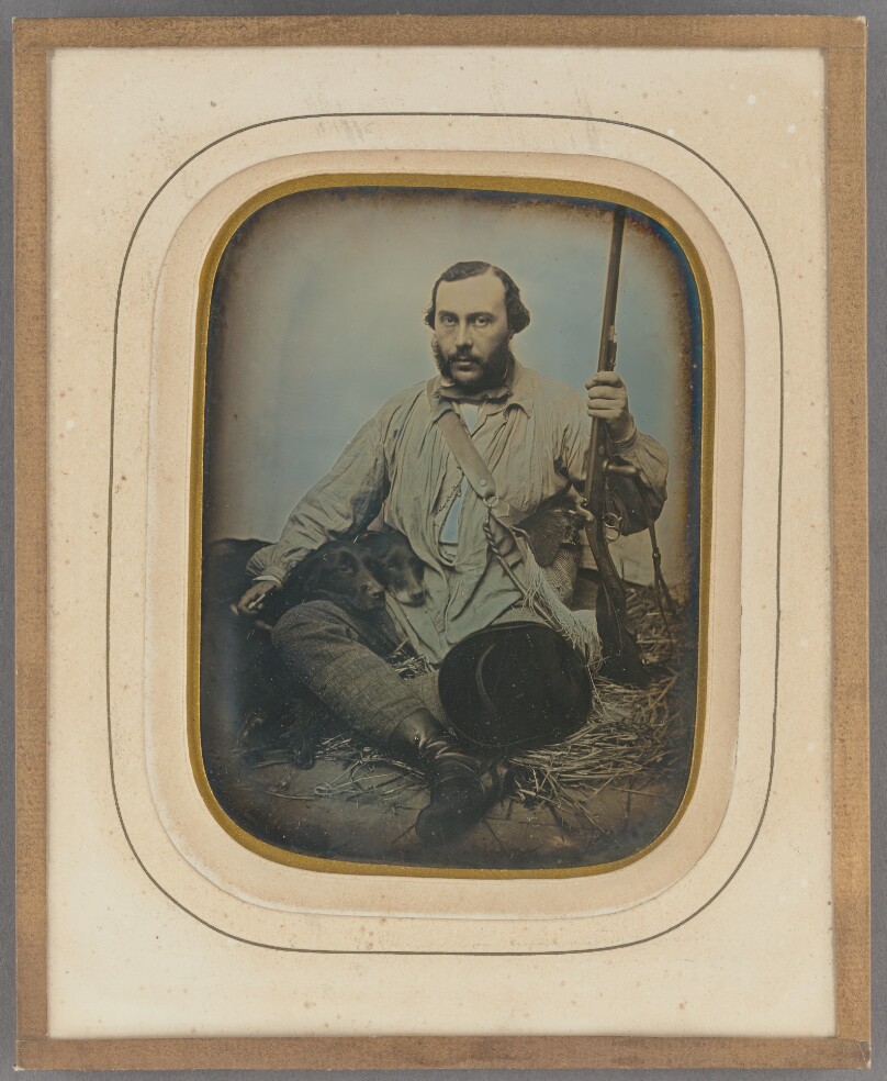[Bearded Hunter with gun and two dogs]