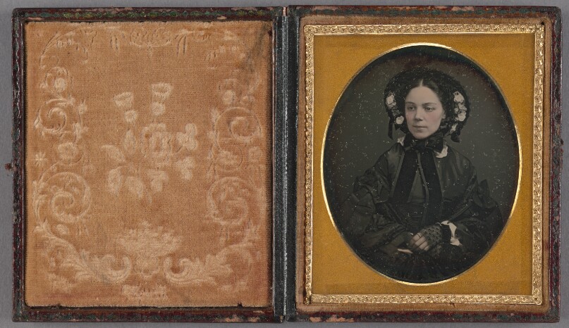 [Unidentified woman wearing a dark bonnet with flowers]