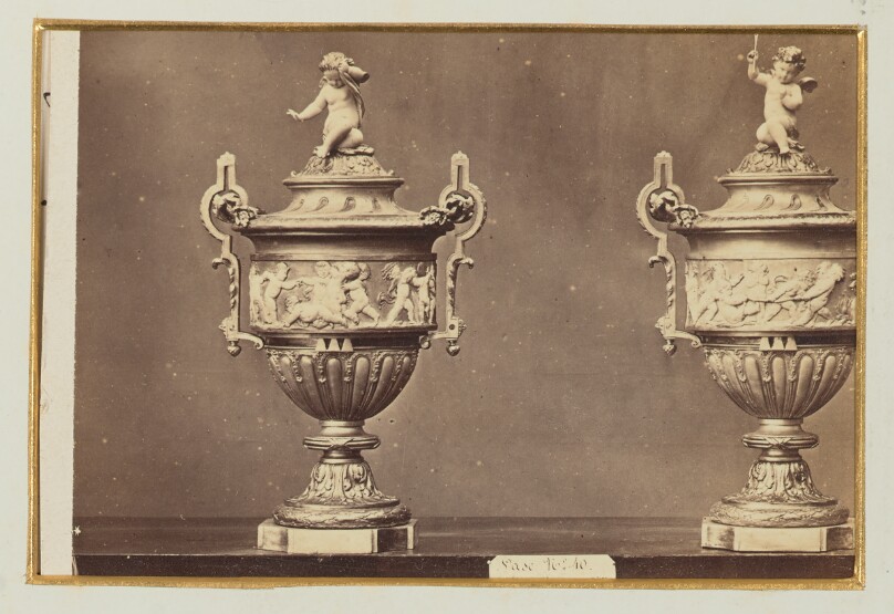 [Two ornate vases with cherubs on top]