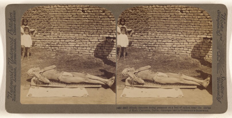 Hindu devotee doing penance on a bed of spikes near the shrine of Kali, Calcutta, India.