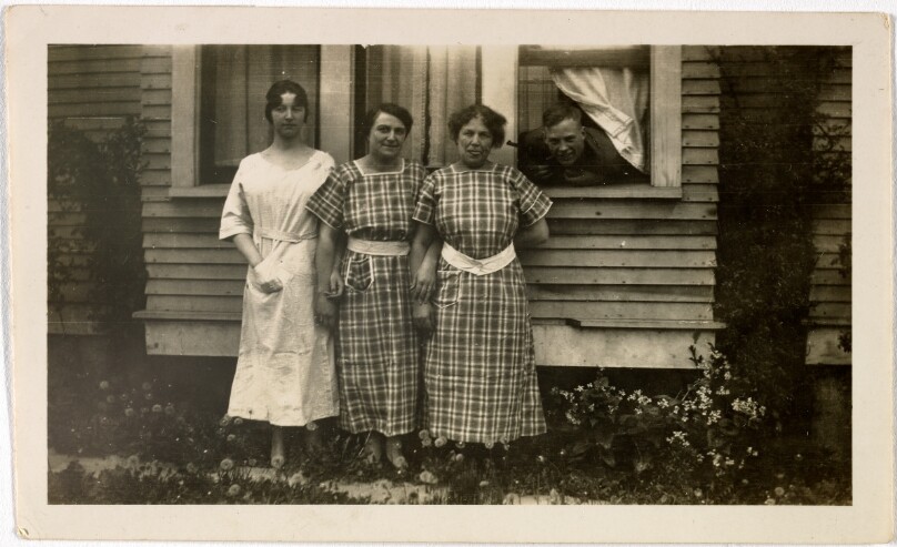 [Three women with man behind them]