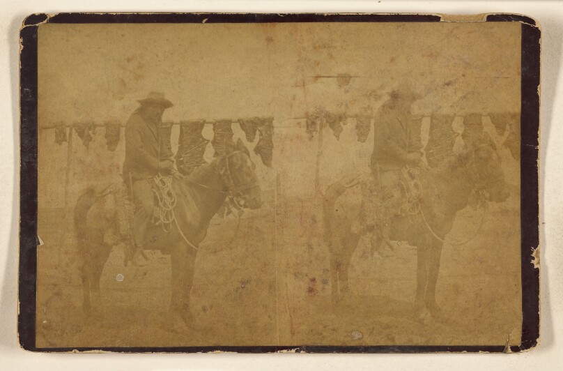 [Indian on horseback, skins drying on pole in background]