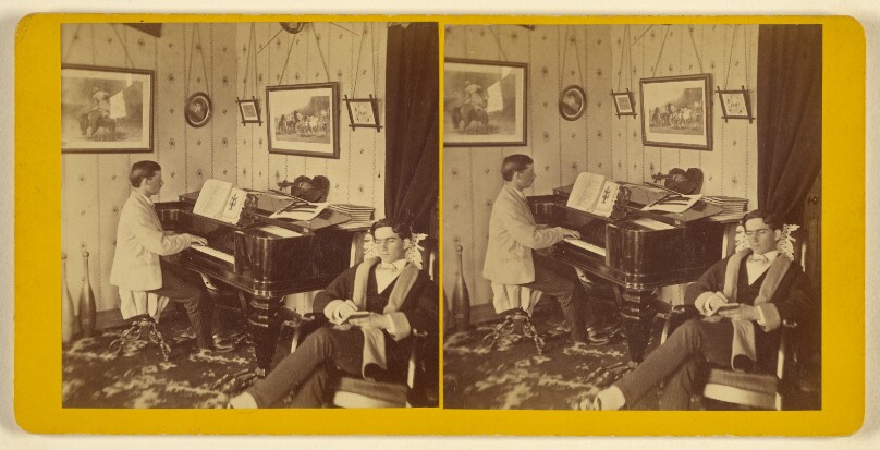[Parlor scene: one young man playing a piano, another seated with small notebook]
