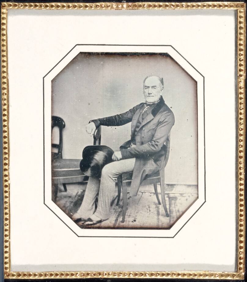 [Portrait of a distinguished-looking, middle-age man seated, holding his top hat]