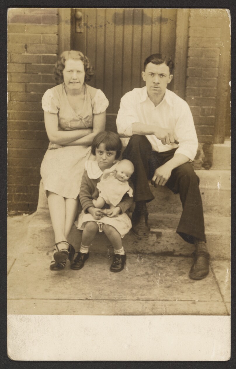 [Family with doll on stoop]