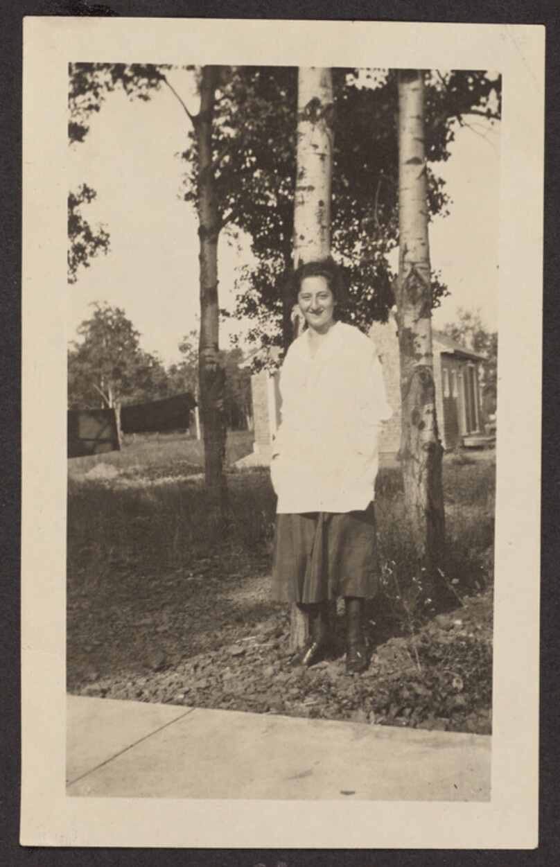 [Woman posing in front of two trees]