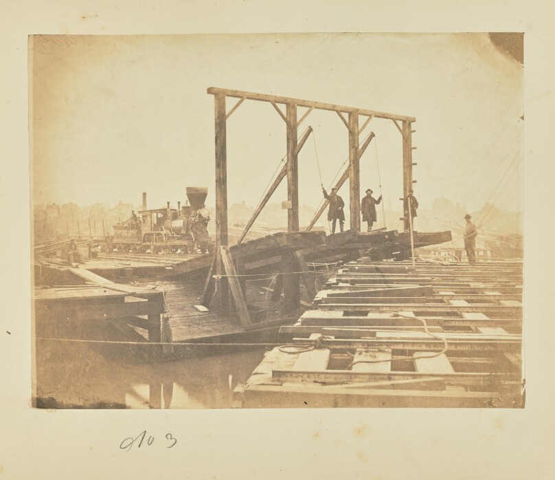 Exhibits the surface of a pair of barges showing the tracks for loading and unloading cars, also the movable bridges by which the tracks of the floats are connected with those on the wharf