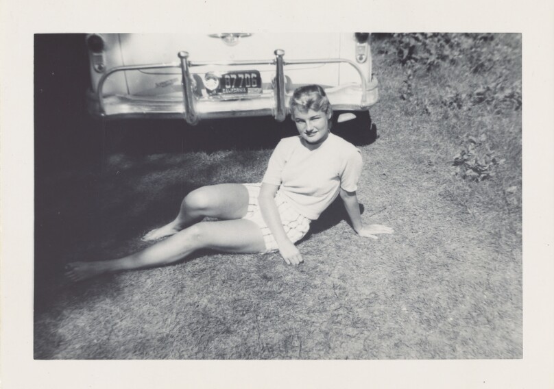 [Young woman sitting with car]