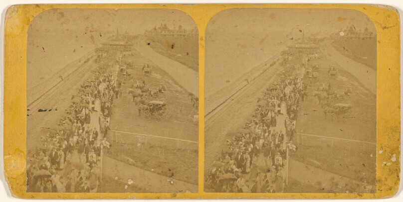 The Plank Walk crowded with people and horse and carriages on other side [Oak Bluffs, Mass.]