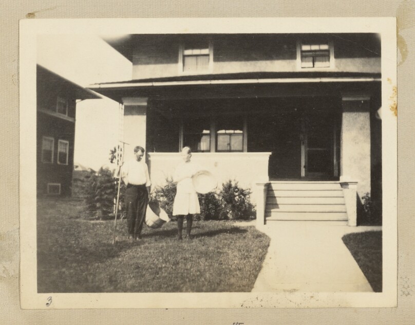 [Two people in front of a house]