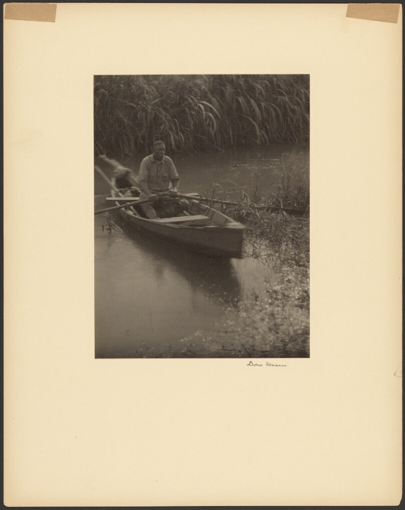 [Black Man Rowing a Small Boat]