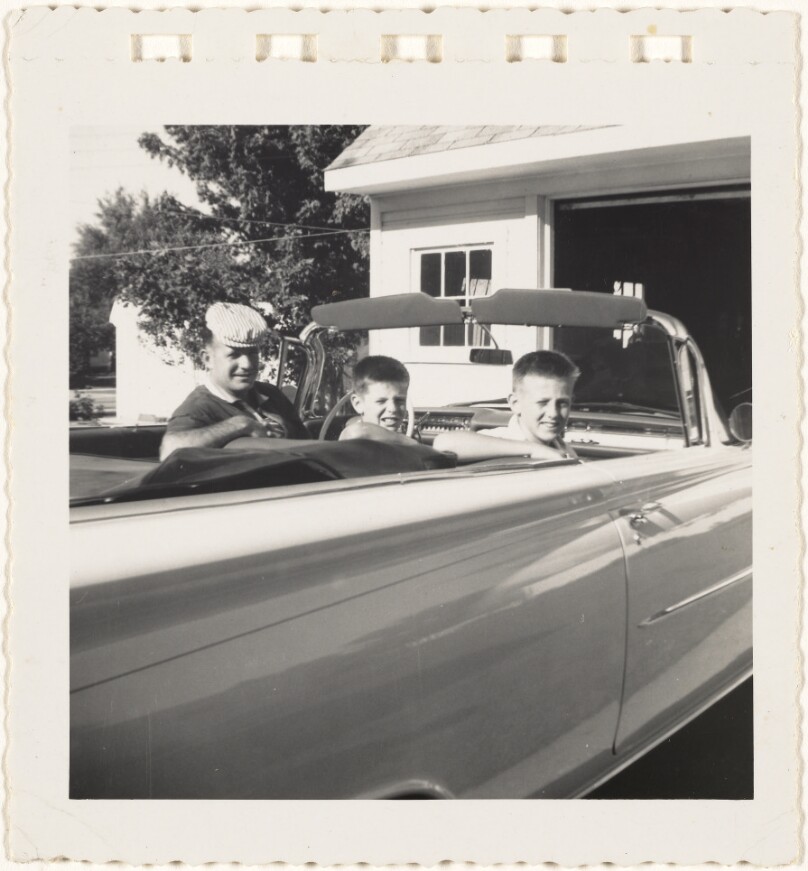 [Man and boys in convertible]