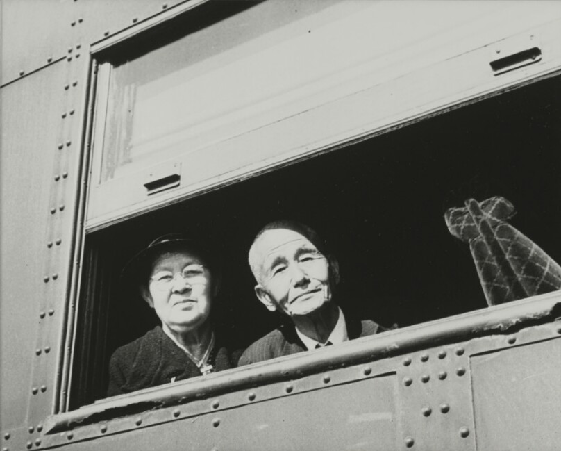 [Man and woman looking out train window]