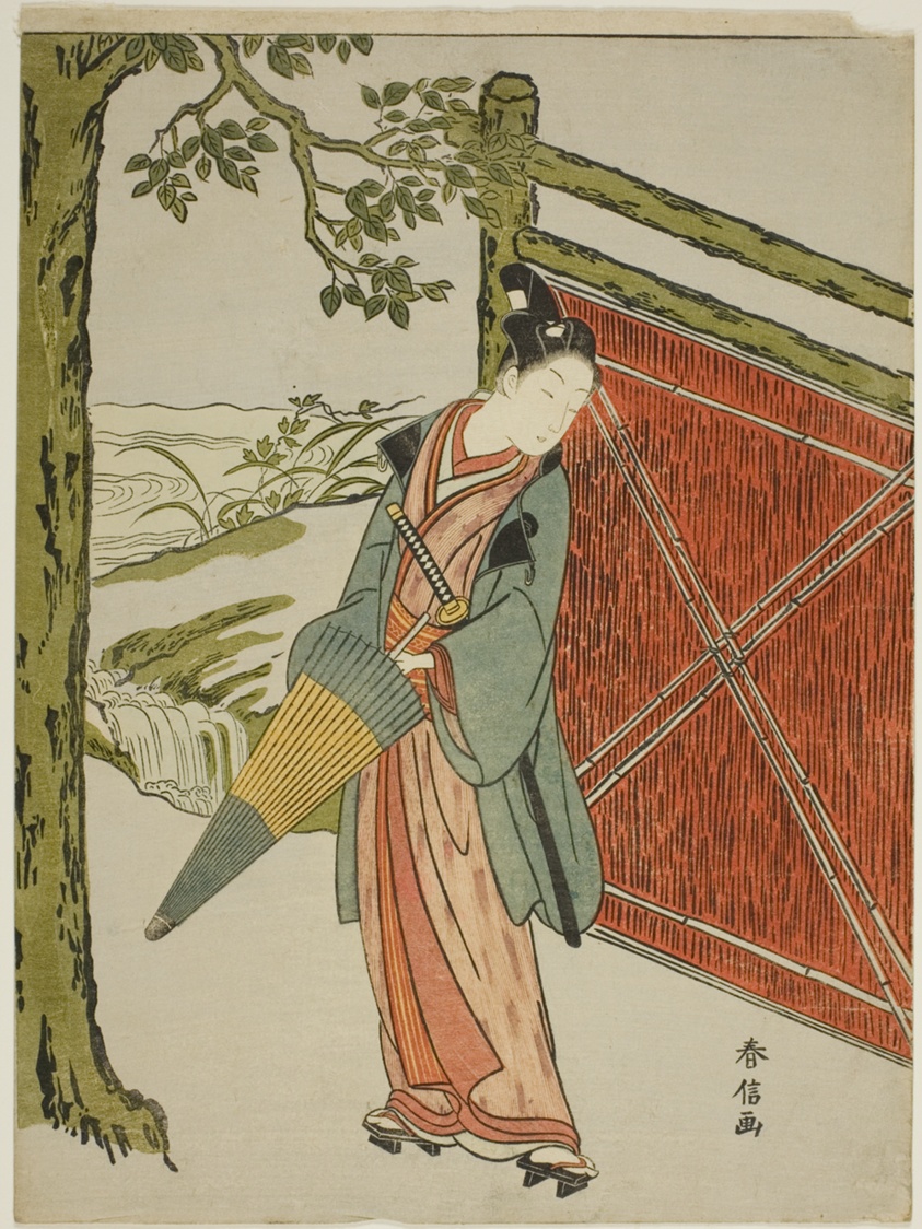 Young Man Holding Umbrella Beside a Fence